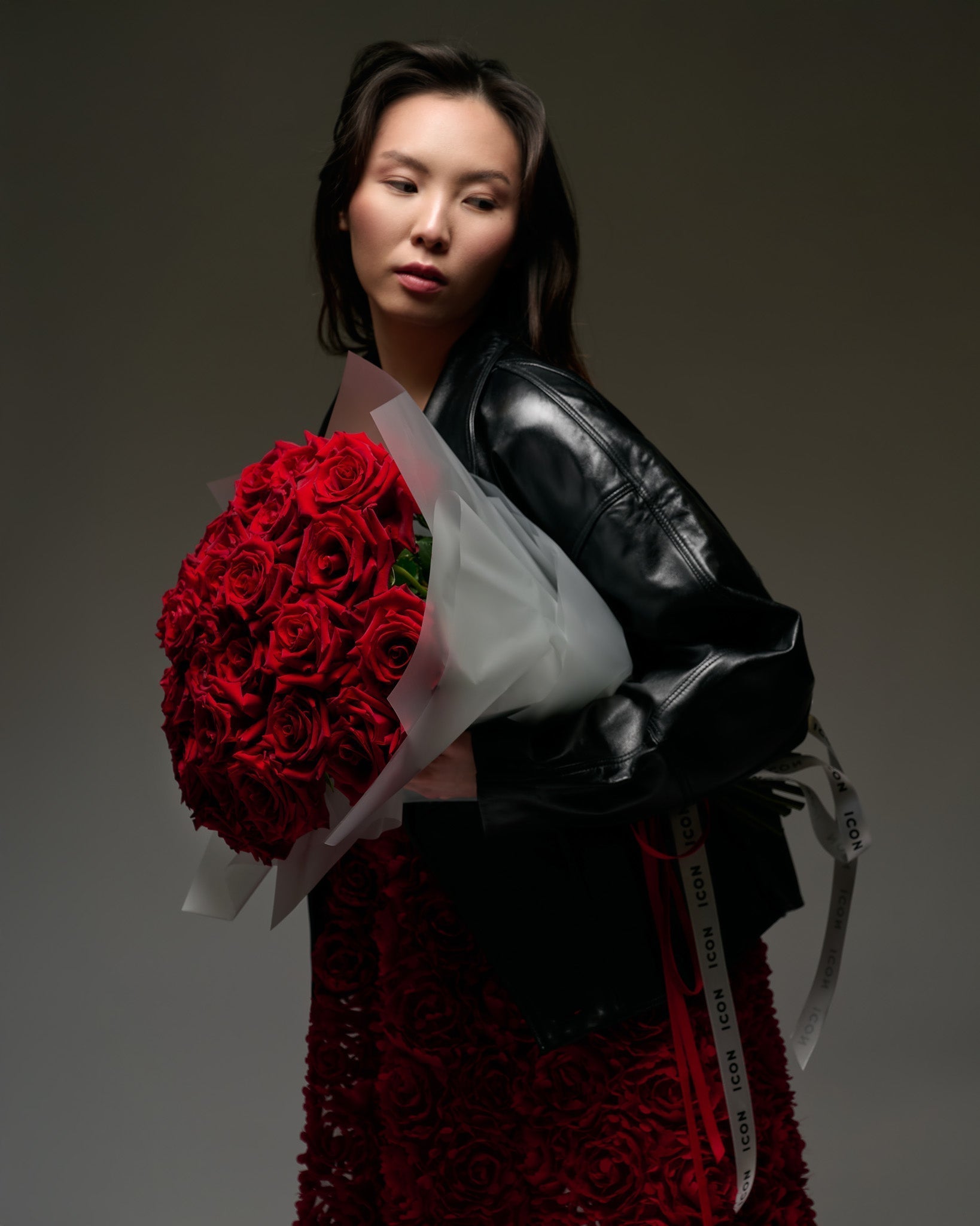 A woman holding a bouquet of red roses