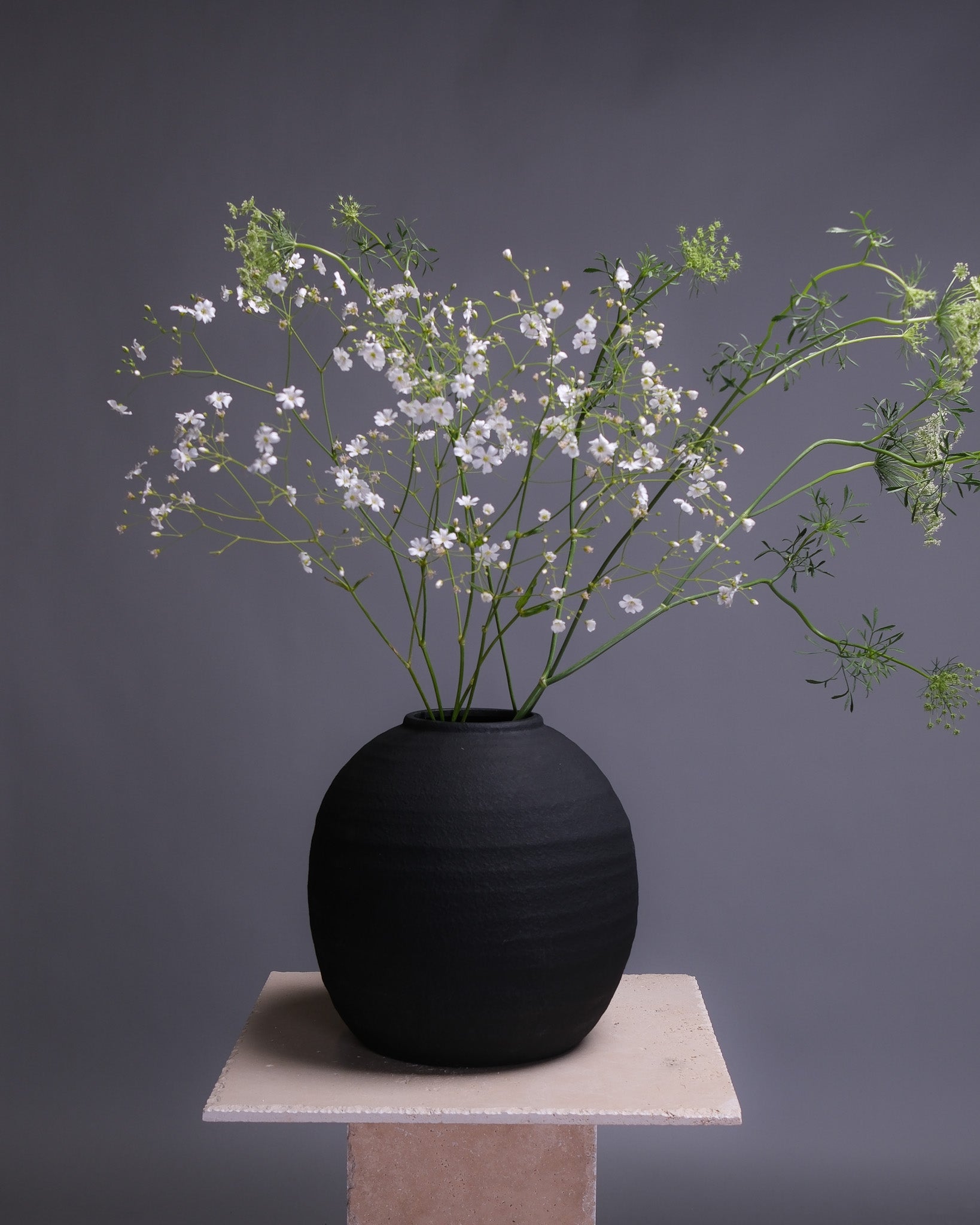 Large black interior vase with a sleek, modern silhouette—perfect for statement floral arrangements or contemporary home decor.