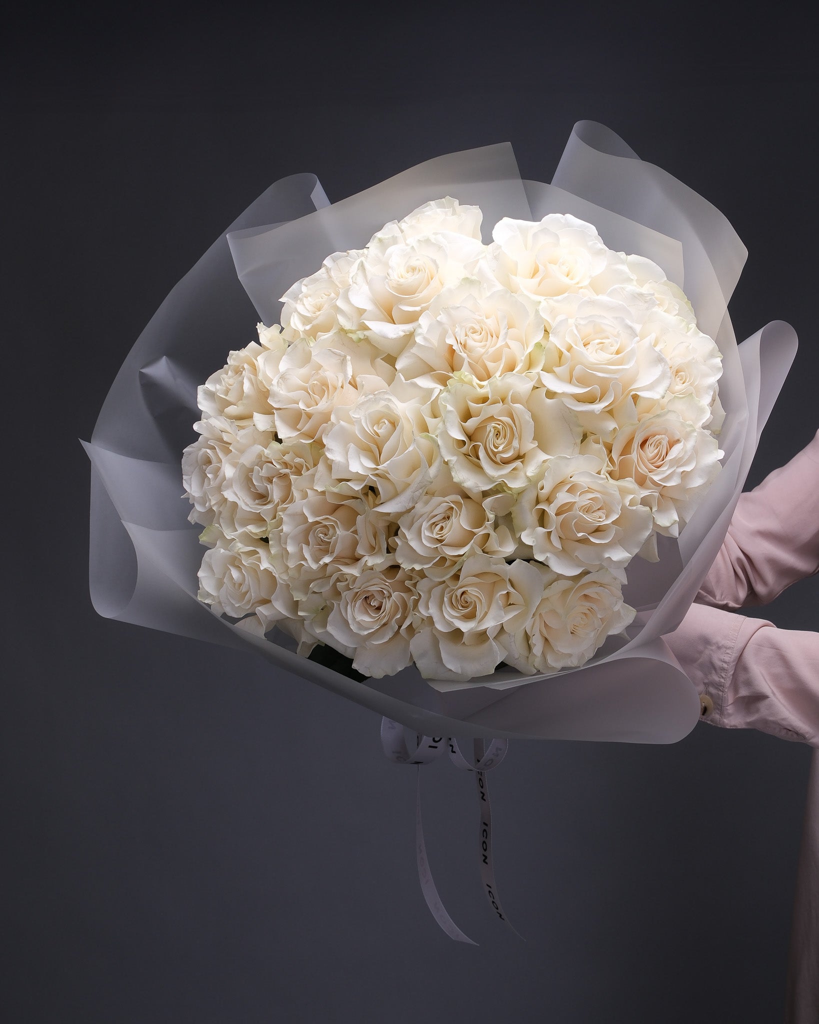 Hand-held bouquet of classic white roses – minimalist and elegant mono arrangement by Flower Icon