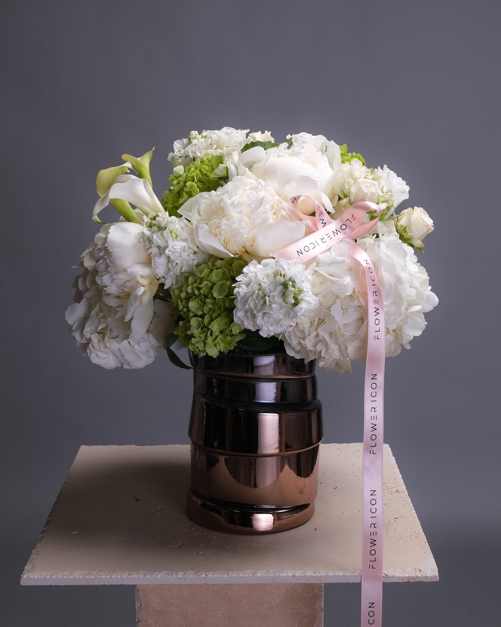 Elegant white floral arrangement in a vase with peonies, hydrangeas, and calla lilies, styled in a refined and sophisticated composition.