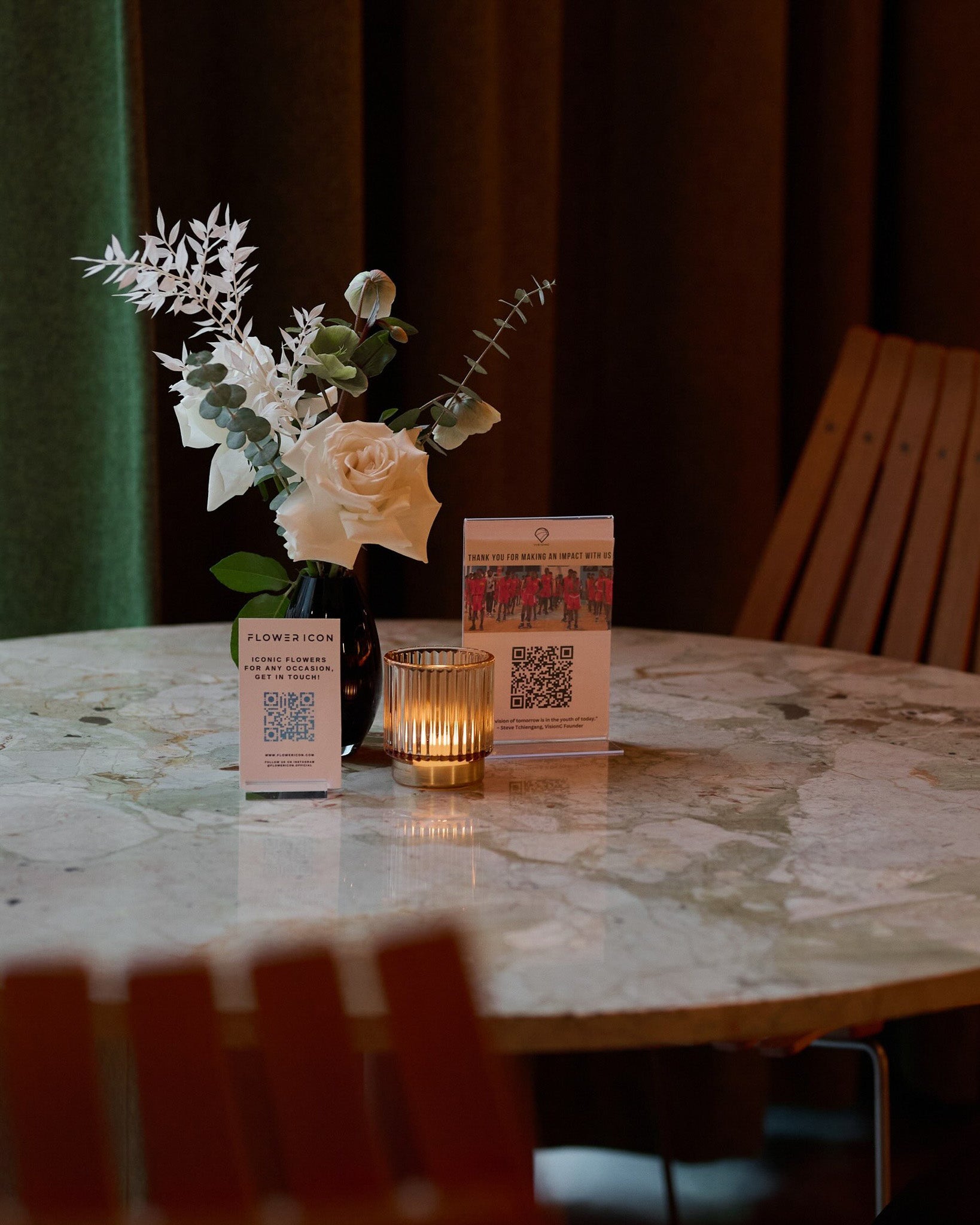 Minimalist table setup with black vases holding elegant white floral arrangements – modern and refined event décor