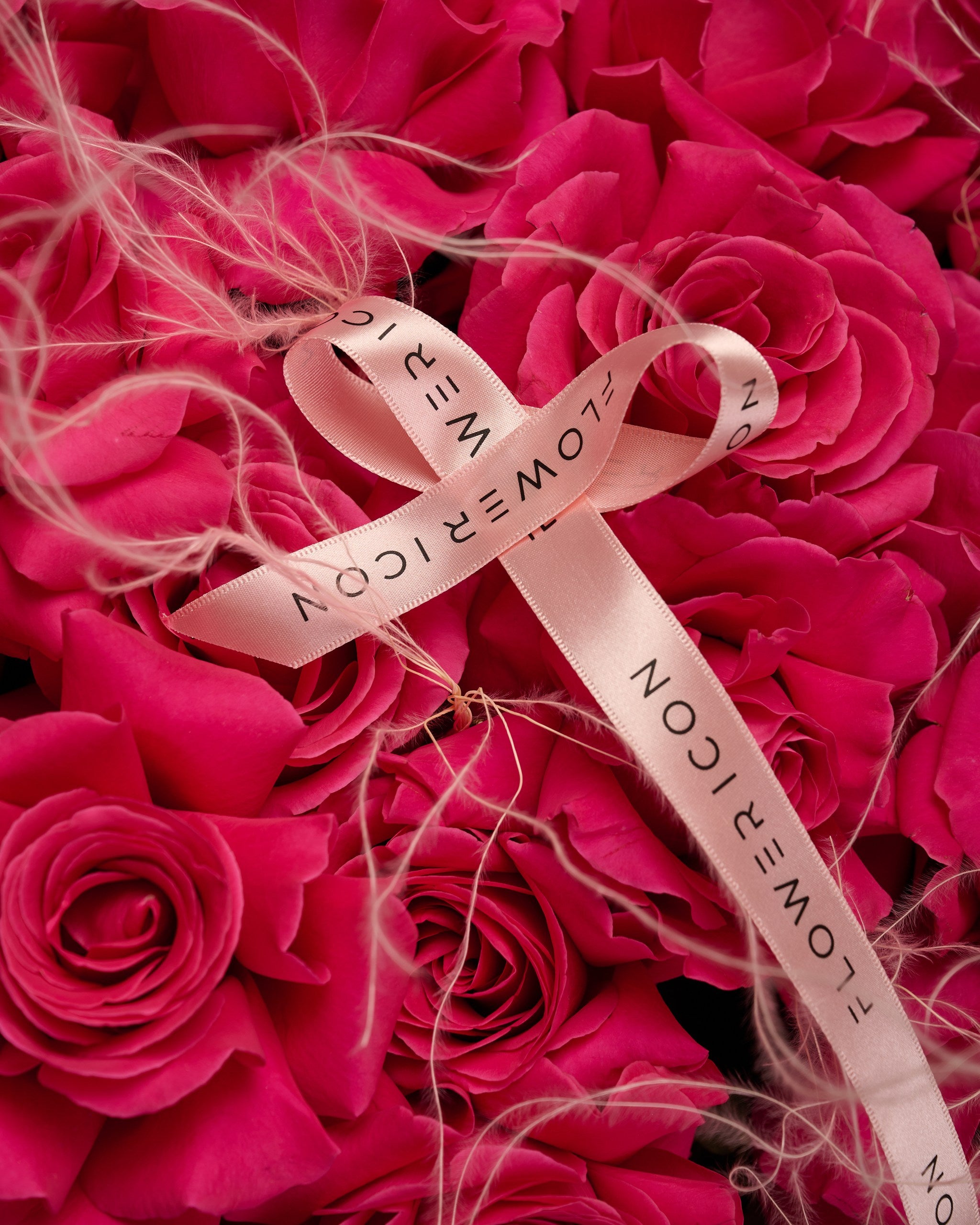 Close-up of fuchsia roses with soft stipa details – bold and textural floral arrangement