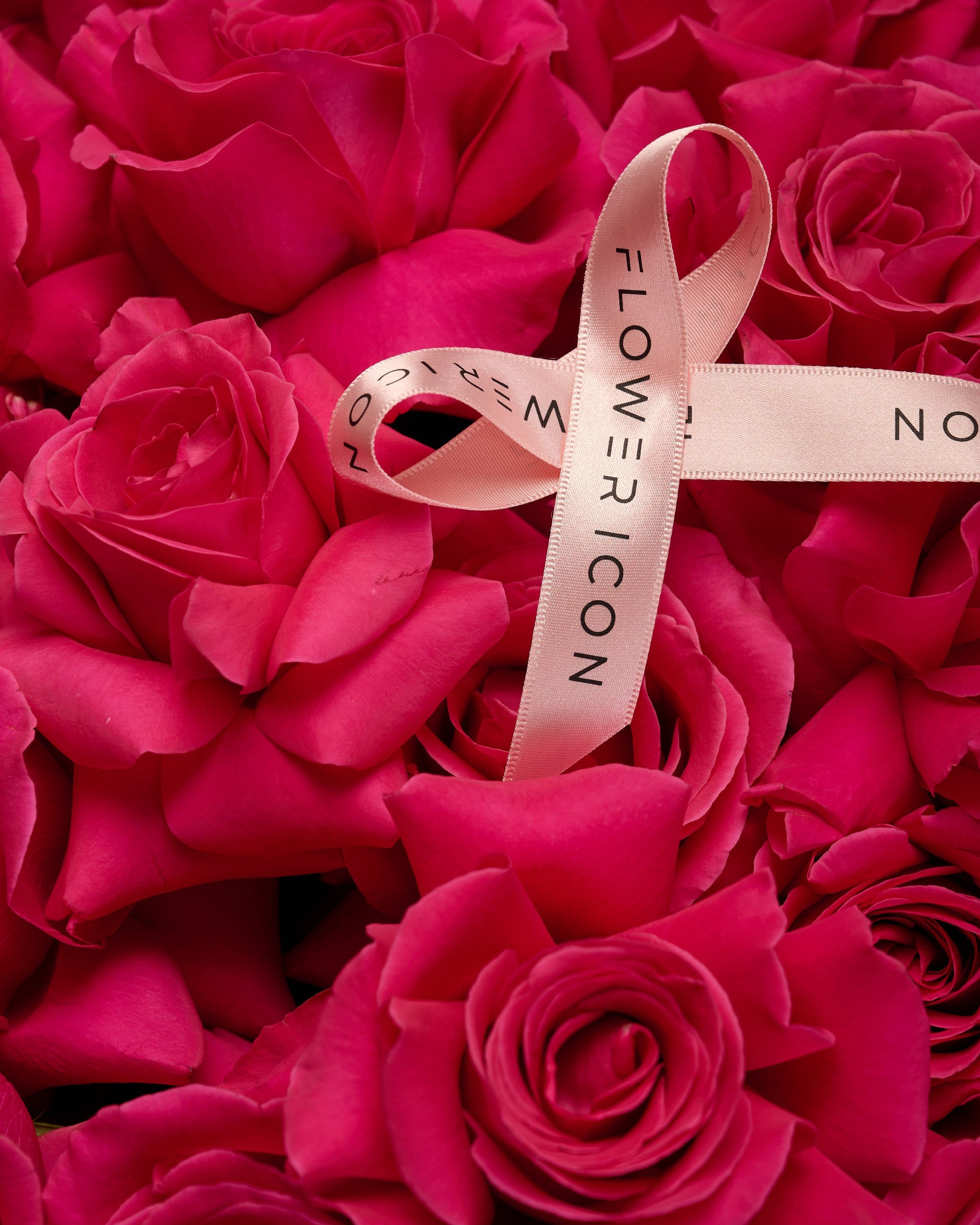Close-up of fuchsia pink roses in a modern basket – striking and elegant flower arrangement by Flower Icon