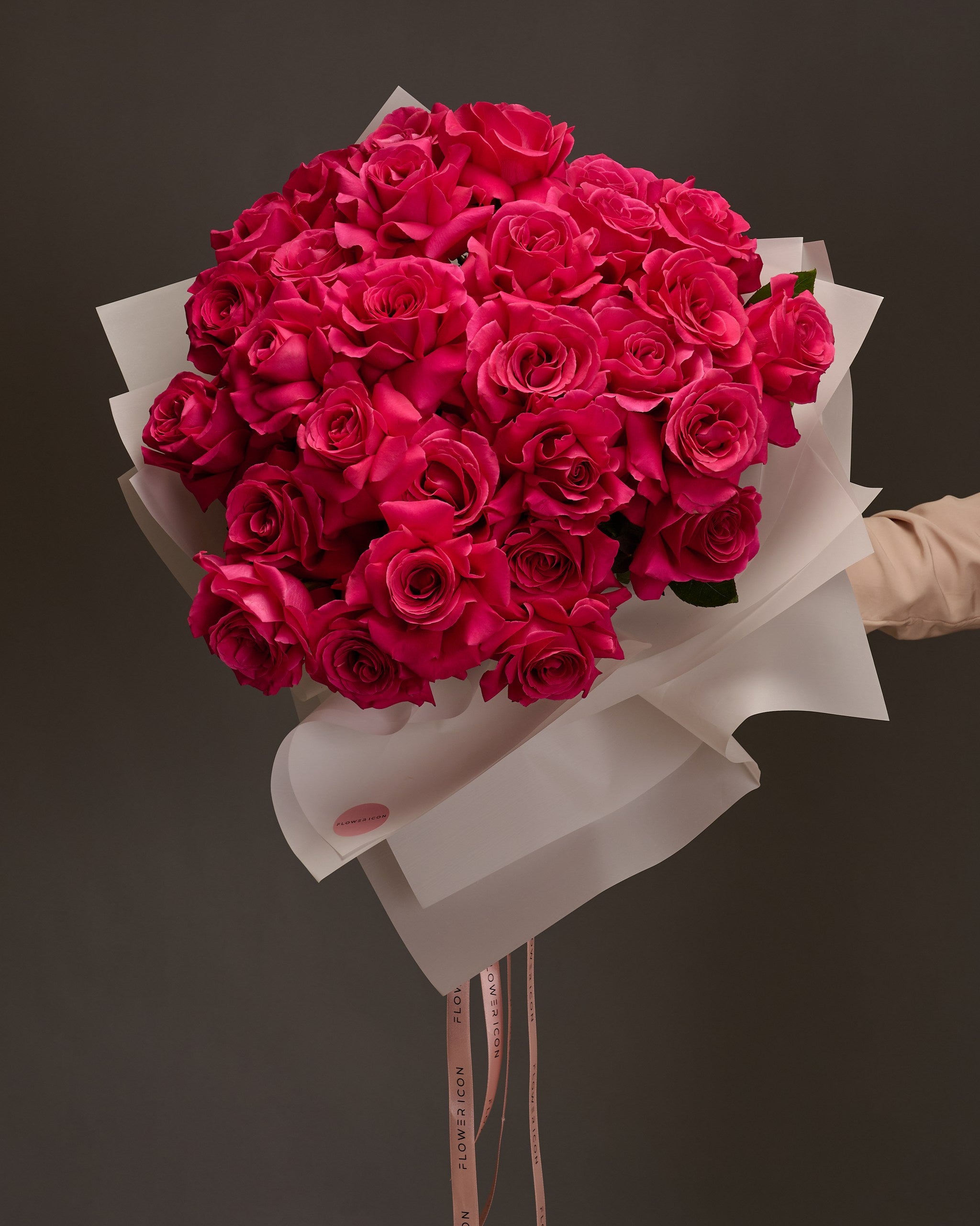 Hand-held bouquet of vibrant fuchsia roses – striking and modern floral gift by Flower Icon