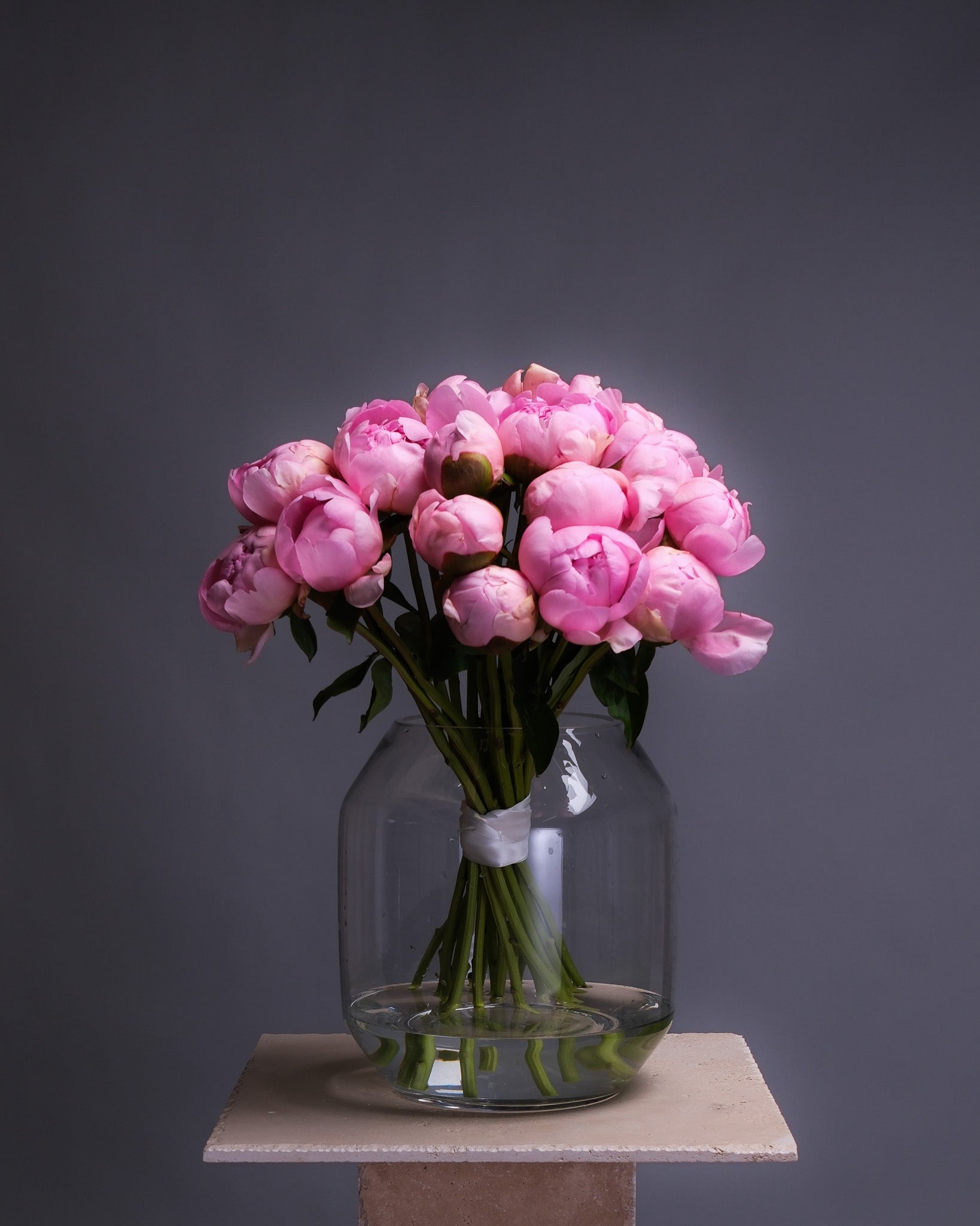 Mono peony bouquet arranged in a clear glass vase, featuring full, round blooms with a soft and elegant look.