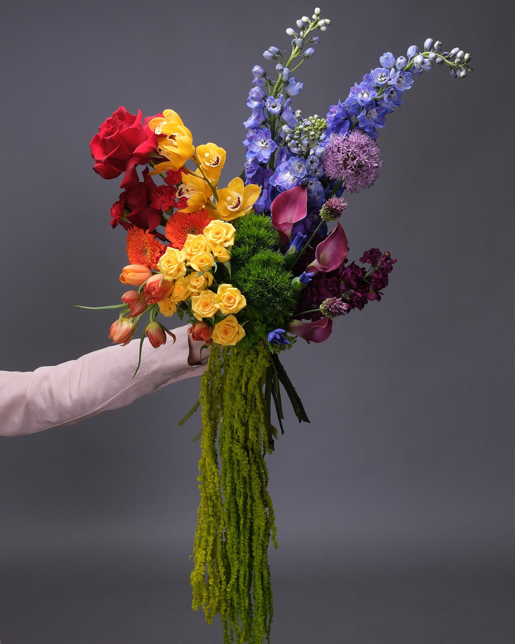 Side view of the lush and oversized Pride floral arrangement showcasing its full rainbow of flowers and textures.