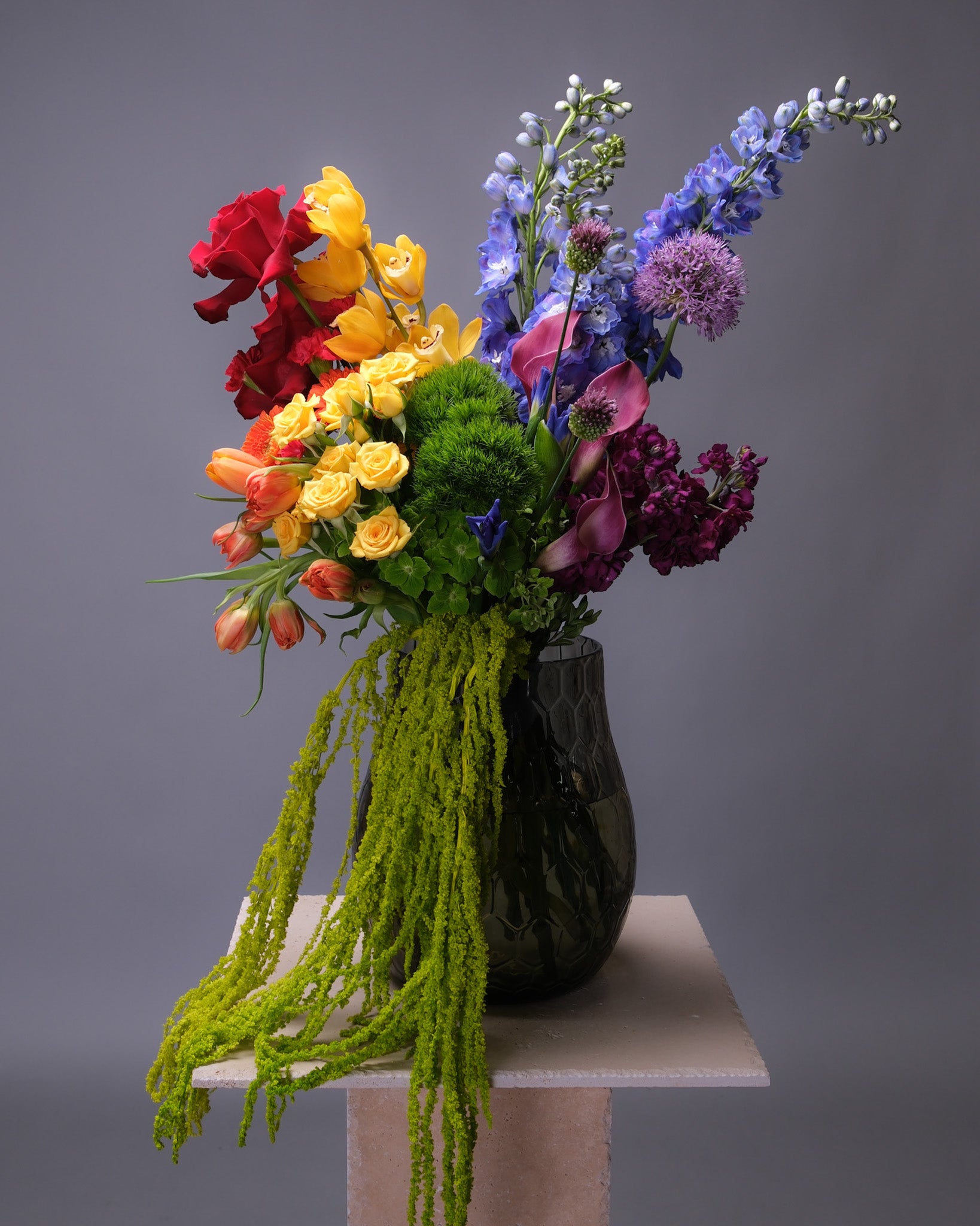 Large Pride bouquet bursting with color, featuring roses, tulips, hydrangeas, calla lilies, orchids, allium, and stock in a vibrant rainbow palette.