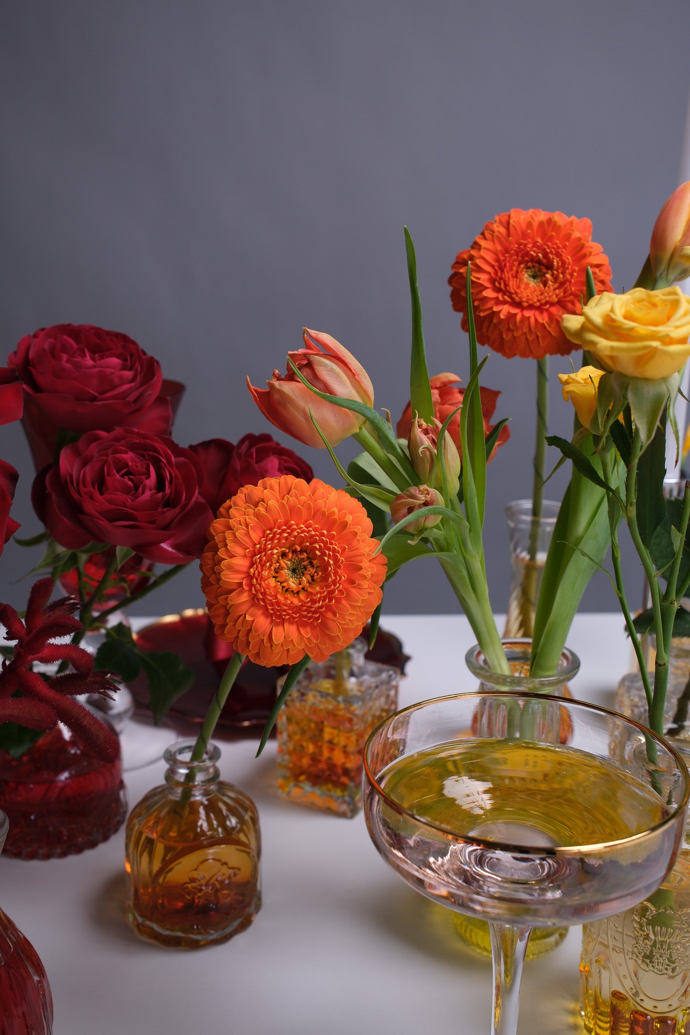 Side angle of the rainbow flower tablescape showcasing colorful arrangements evenly spaced along the table with a festive, modern aesthetic.