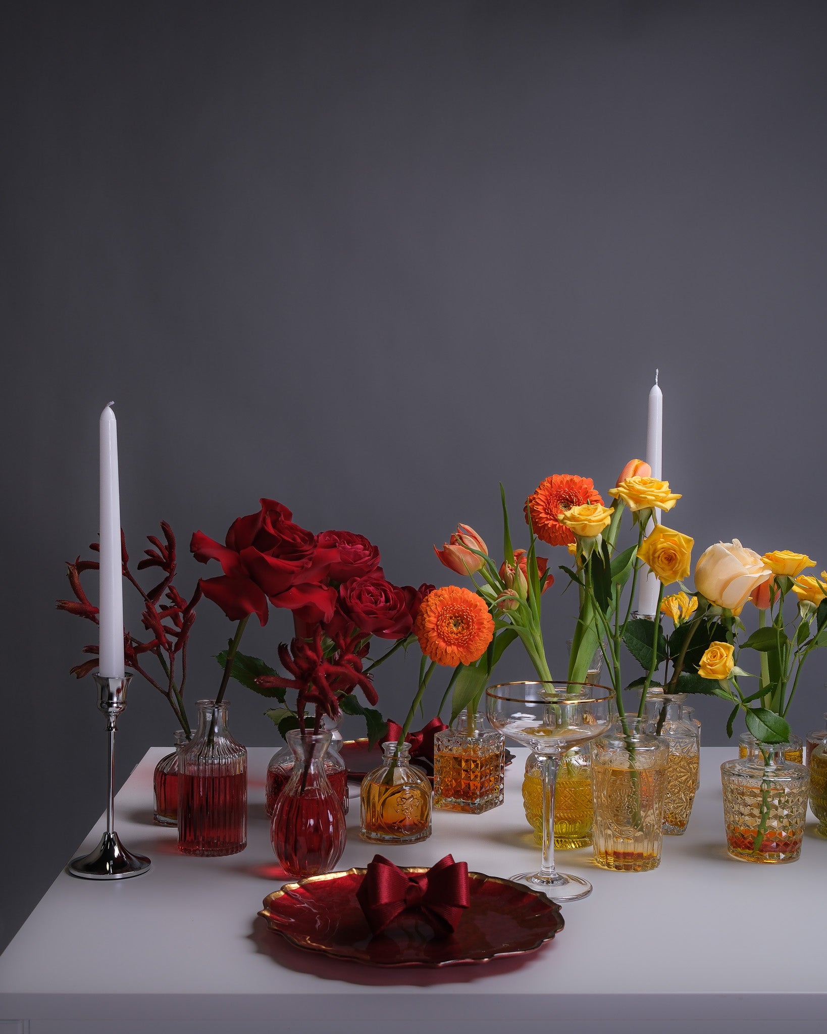 Elegant rainbow-themed table setup with vibrant floral arrangements in every color, styled across a long tablescape for a bold, celebratory look.