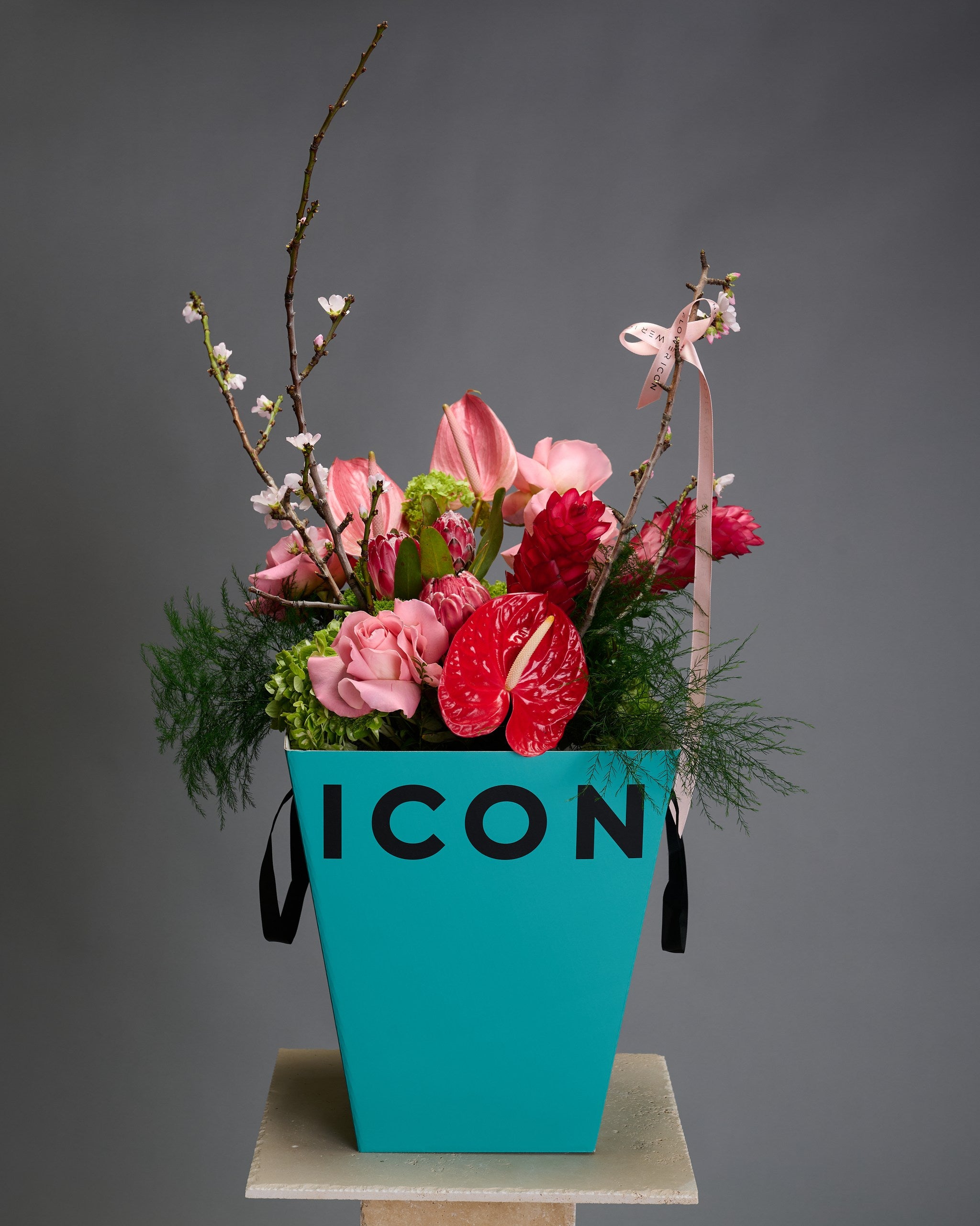 Exotic Blooming Gatsby bouquet in Flower Icon's blue box featuring hydrangeas, cherry blossoms, and anthuriums