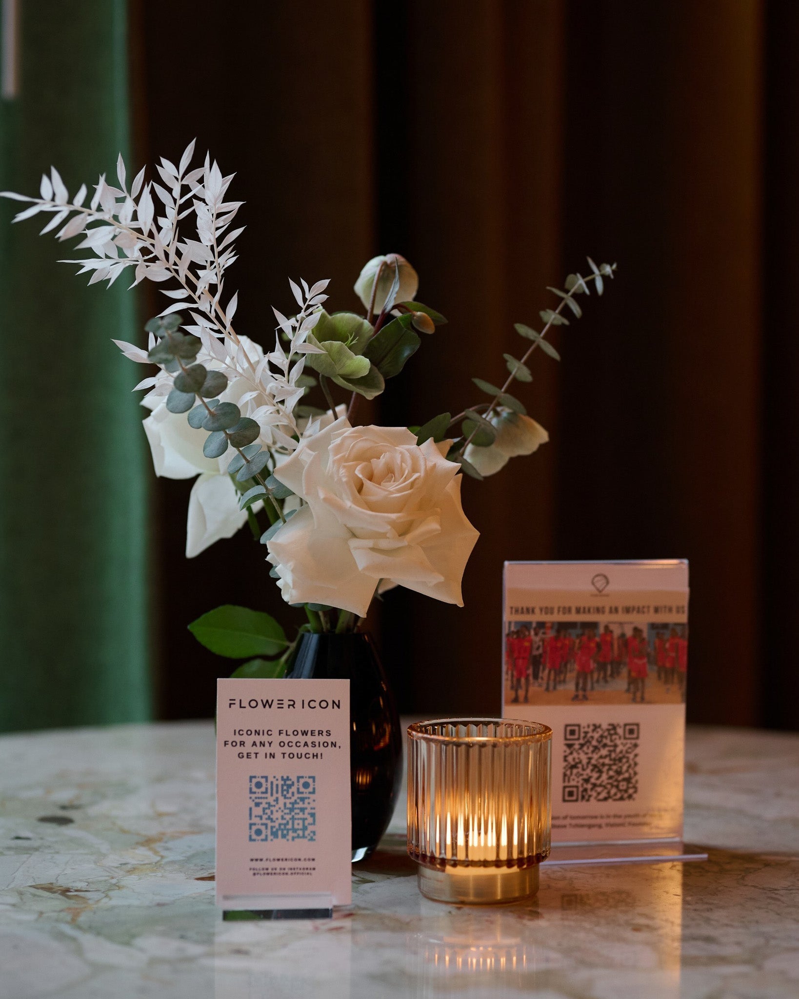 Close-up of small white flower arrangement in sleek black vase – stylish and contemporary table accent