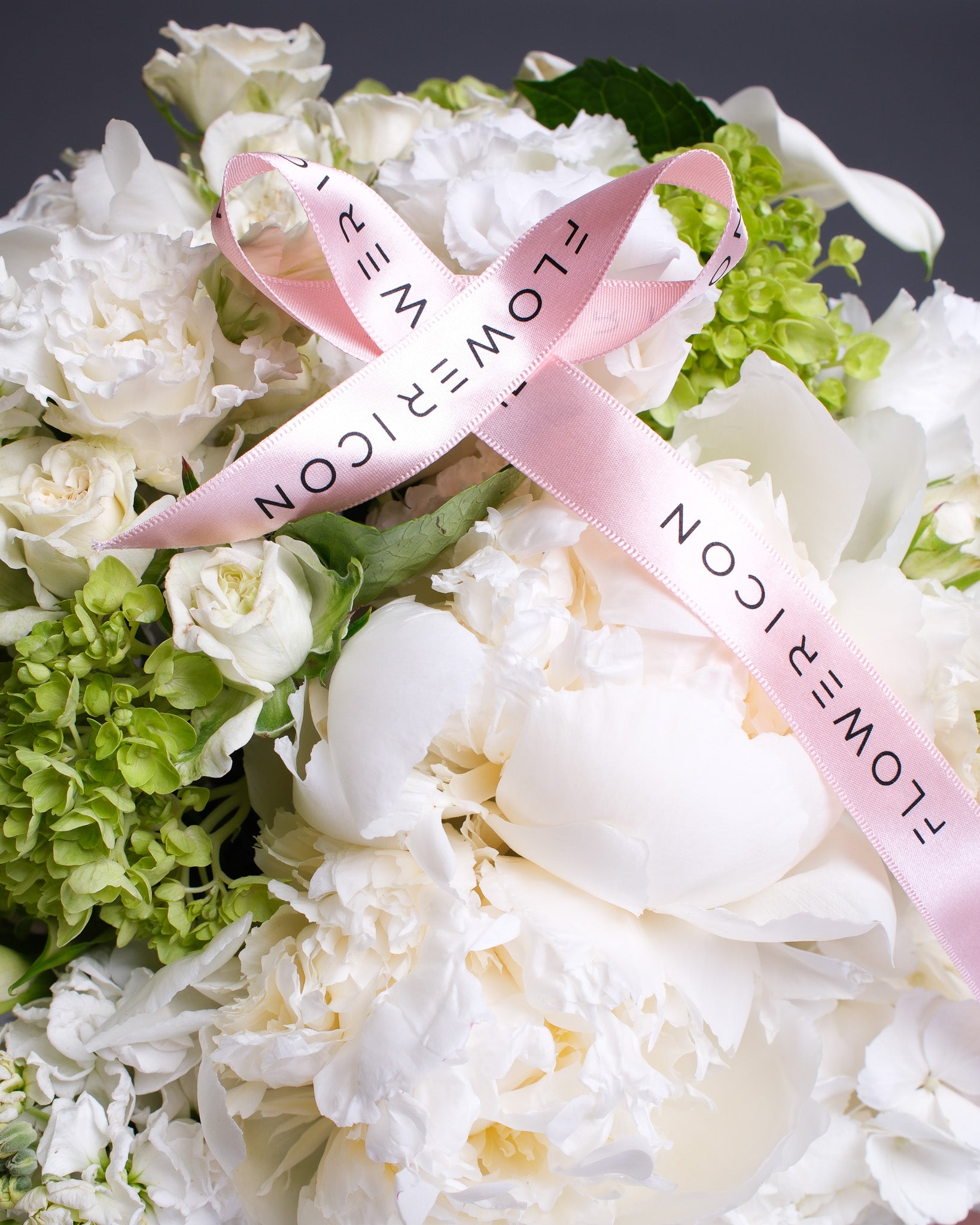 Close-up of white peonies, calla lilies, and hydrangeas highlighting the soft textures and luxurious feel of the bouquet.