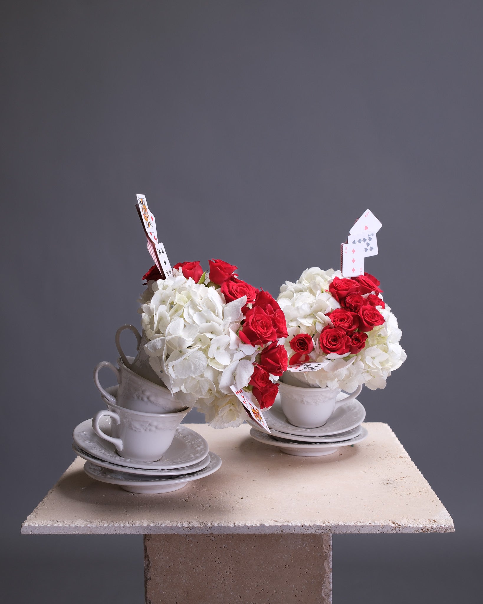 Decorative floral arrangement in teacups on a gray background