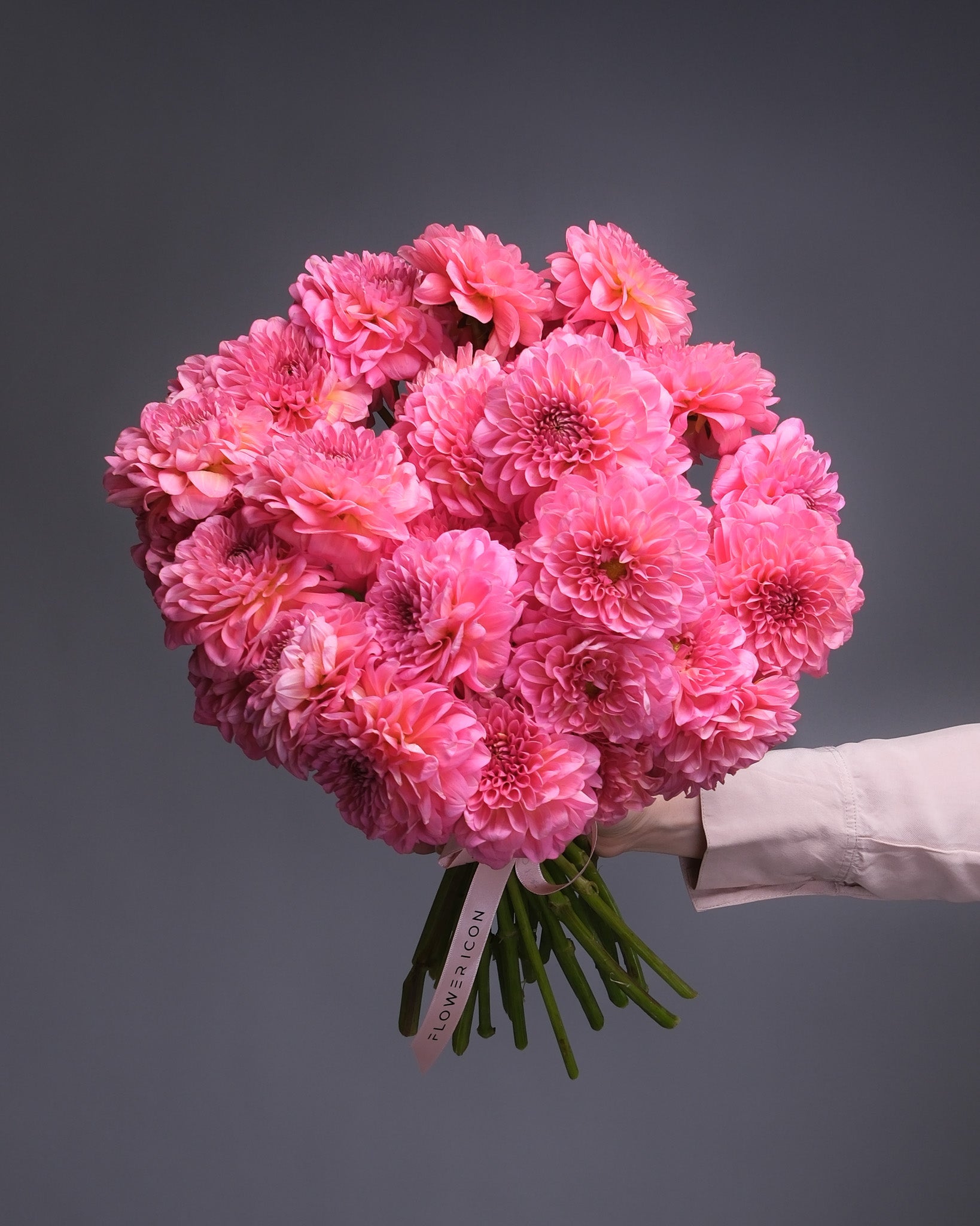  Side view of a dahlia bouquet held by hand, showcasing lush textures and bold summer flower colors.