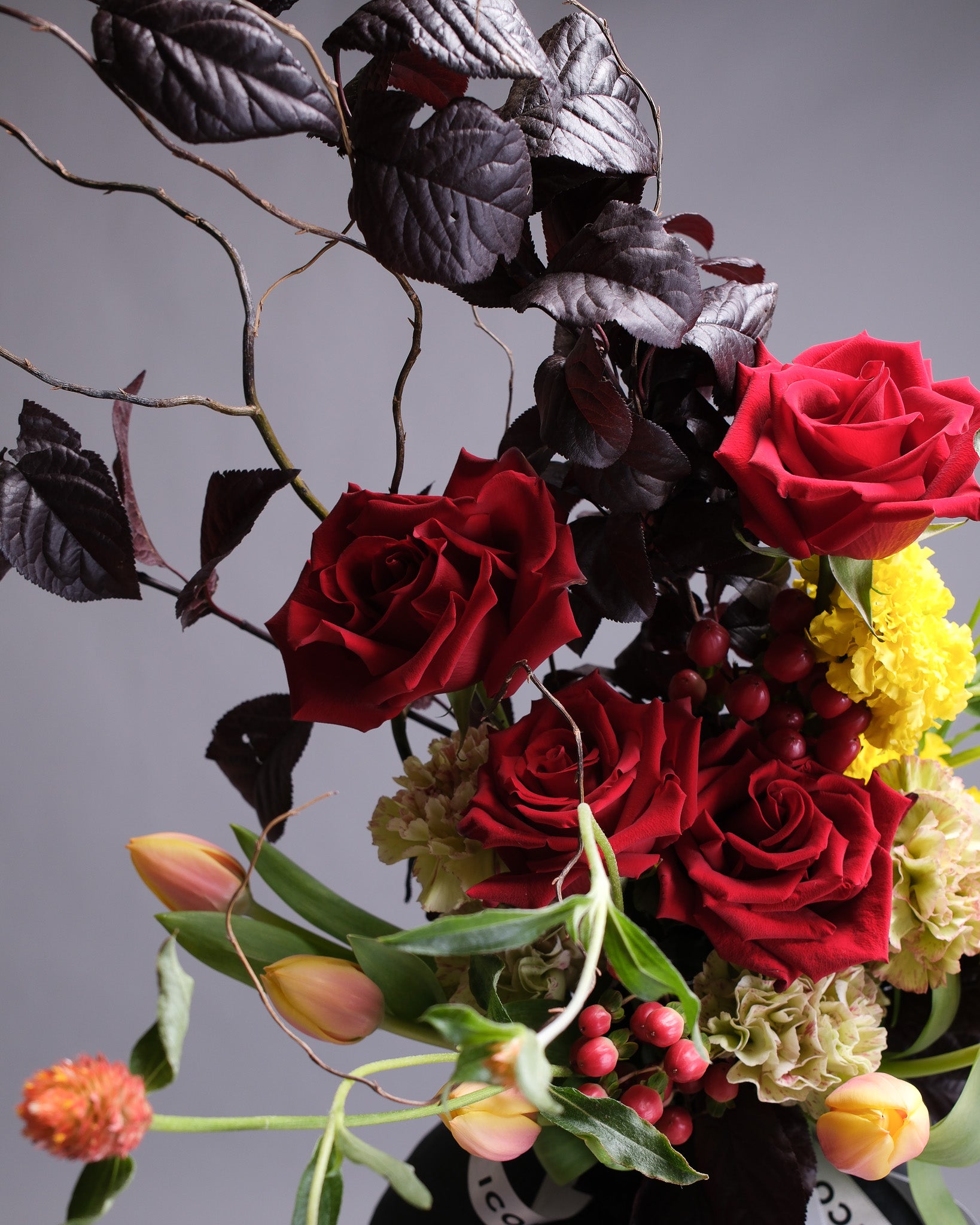 Bouquet of red roses and other flowers with a gray background