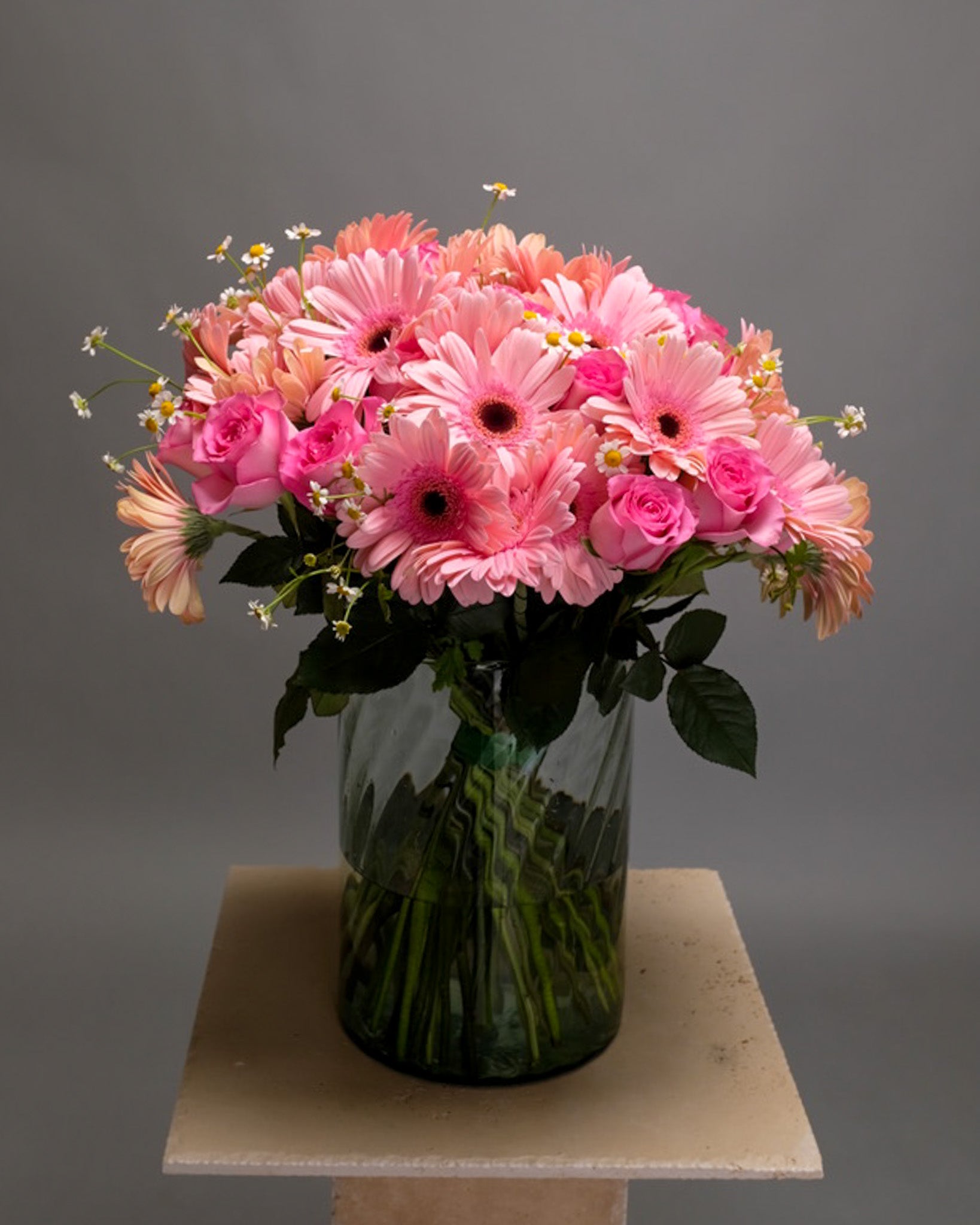 Bouquet of pink roses, Gerbera daisies, and feverfew in a vase – soft, cheerful, and feminine flower arrangement