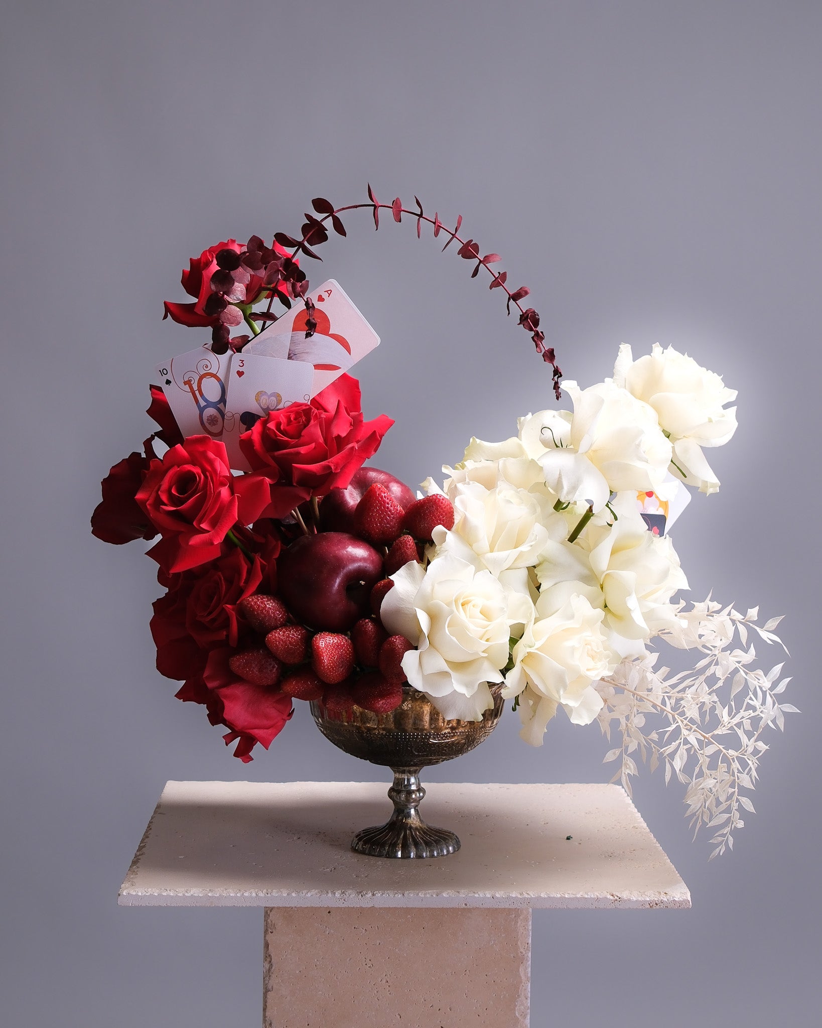 Floral arrangement with red and white flowers on a gray background