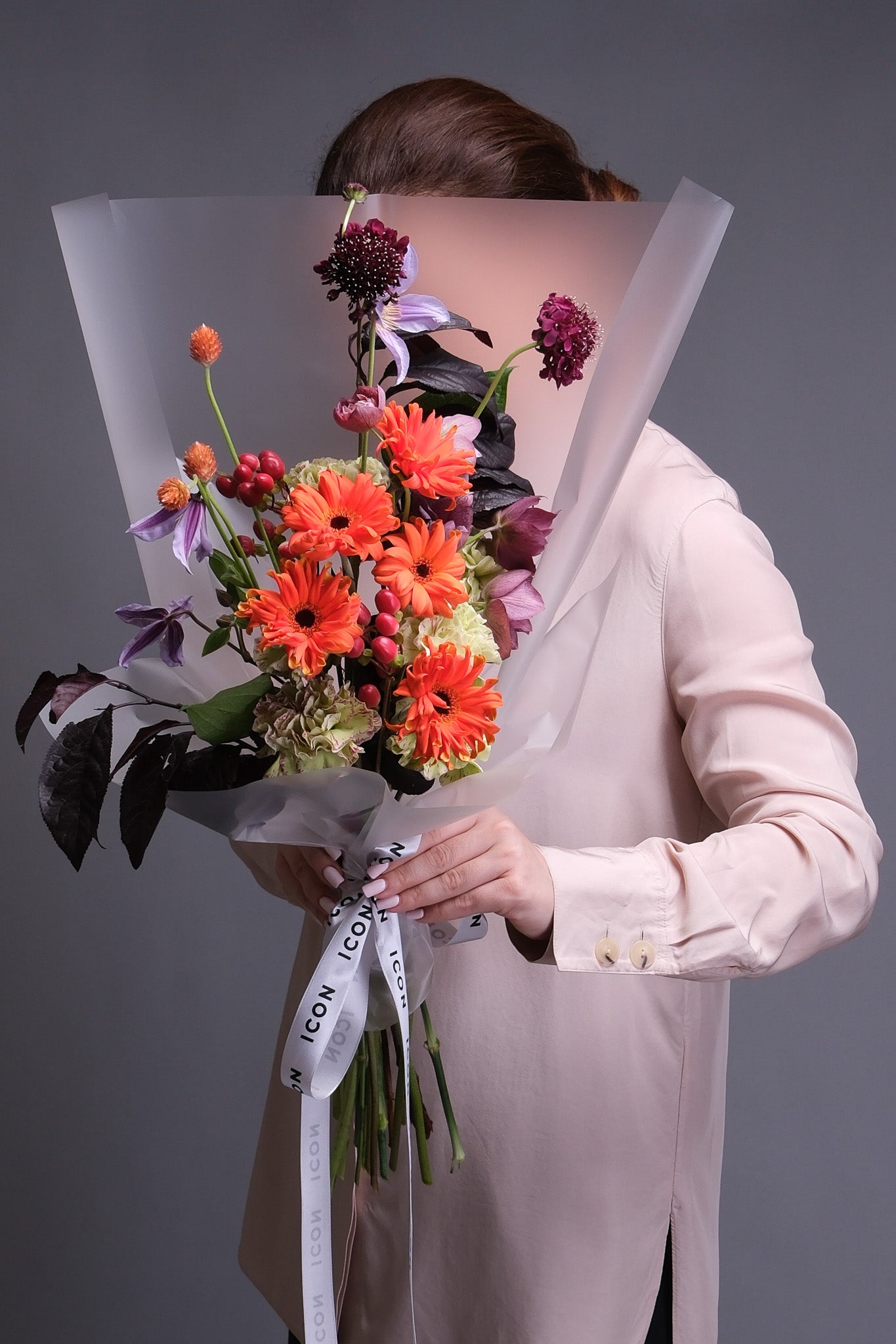 Person holding a fall inspired bouquet of flowers 