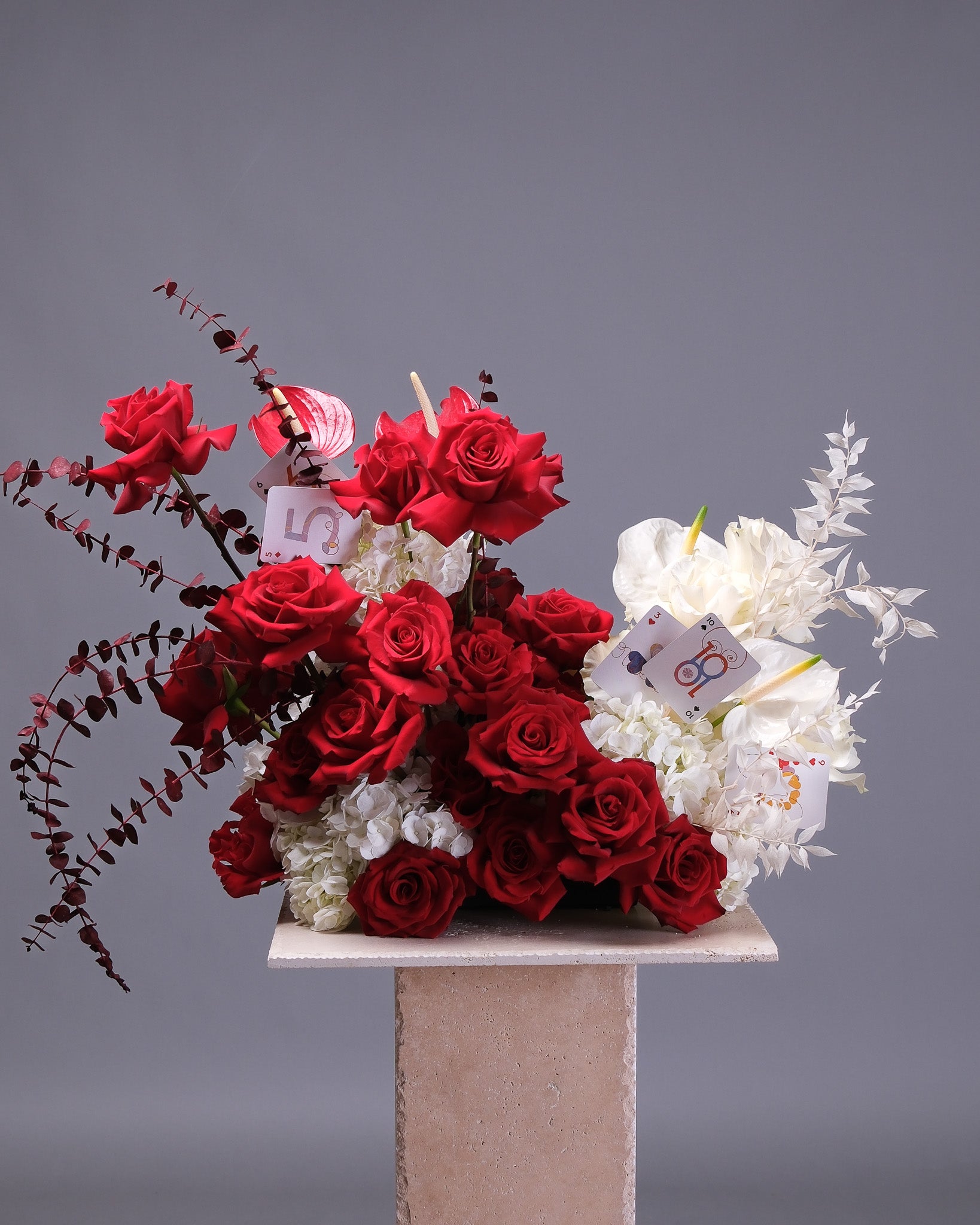 Arrangement of red and white flowers on a gray background